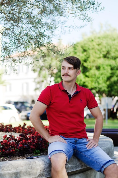 Young happy handsome bearded man, tourist walking in city of Koper. Sunglasses. Hipster