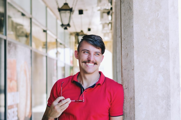 Photo young happy handsome bearded man, tourist walking in old city of koper. summer vacation.