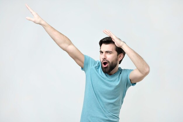 Young happy hispanic man in blue tshirt dancing