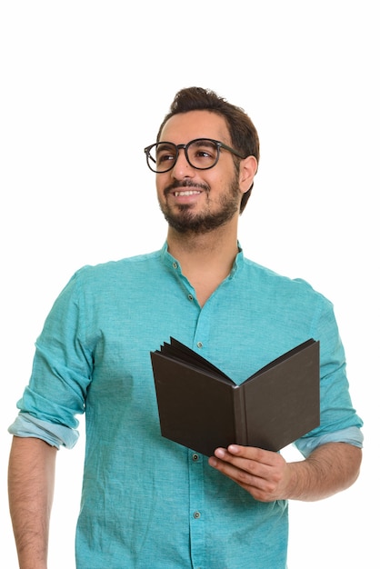 Молодой счастливый индийский мужчина держит книгу, думая