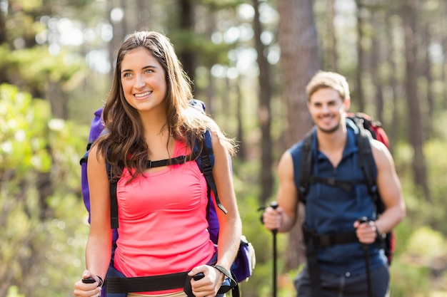 Young happy joggers hiking with trekking poles