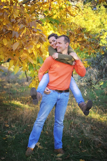 秋の公園で若い幸せな愛のカップル