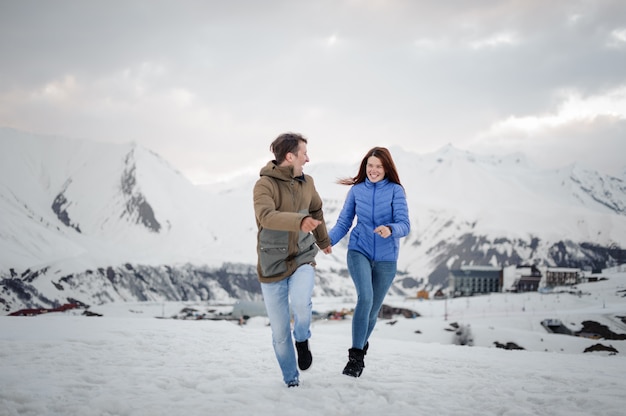 Young and happy lovers on the winter  spending time in mountains