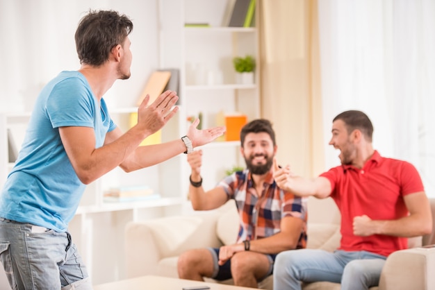 Young happy male friends have fun at home.