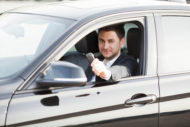 Young happy man bought new modern car