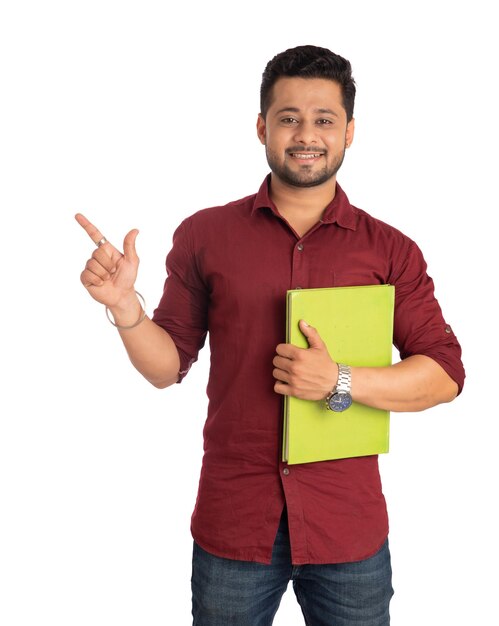 Young happy man holding and posing with the book on white background