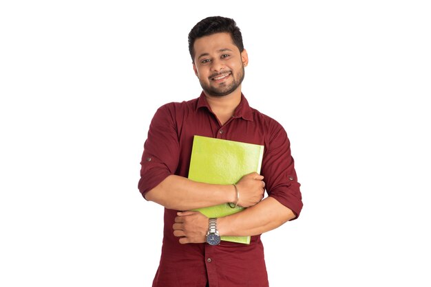 Young happy man holding and posing with the book on white background