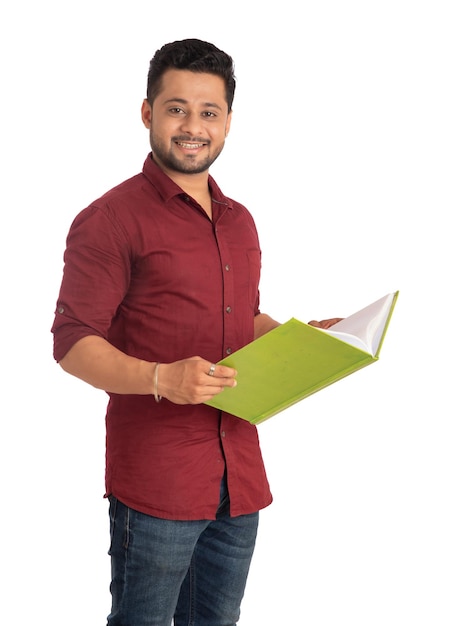 Young happy man holding and posing with the book on white background