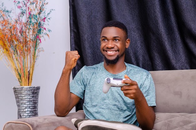 Young happy man laughing and playing video games on weekend