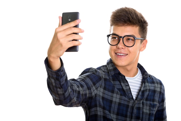 スマートフォンでselfie写真を撮っている間笑顔若い幸せな男