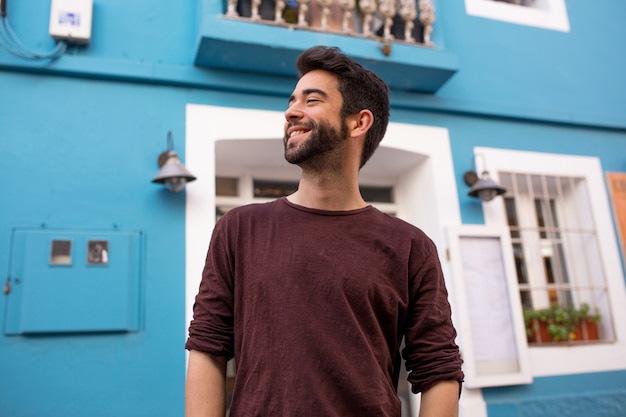 Young happy man walking through the city