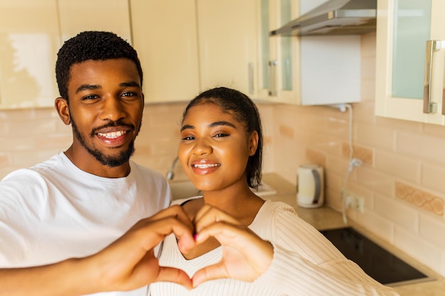 Young happy mixed race couple spending their time at home in the kitchen