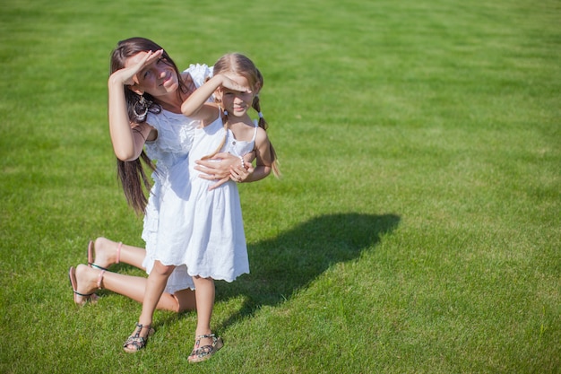 Young happy mother and her daughter having fun outdoors