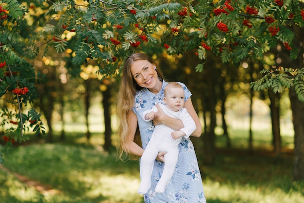 A young happy mother holds her little son in her arms