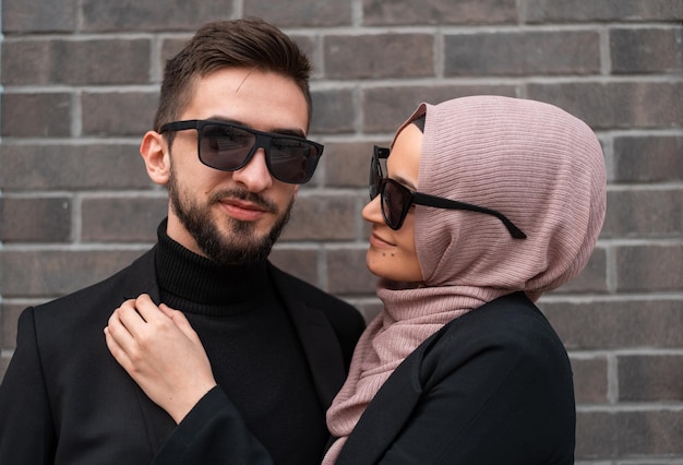 A young happy Muslim fashionable couple posing outside