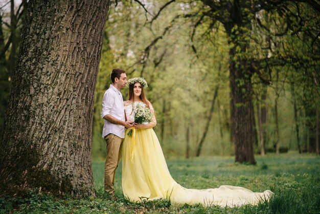 Young happy newlyweds hugging in a spring park