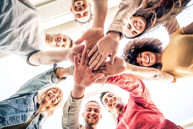 Young happy people stacking hands together outcoor 