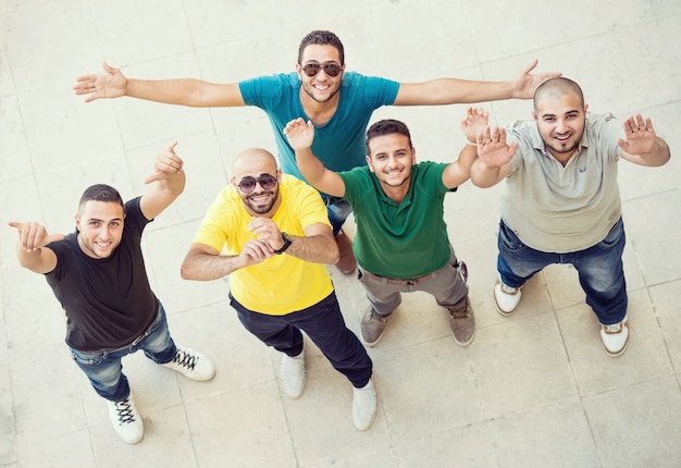 Young happy people standing and talking together on university campus