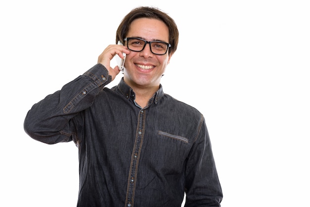 young happy Persian man smiling while talking on mobile phone