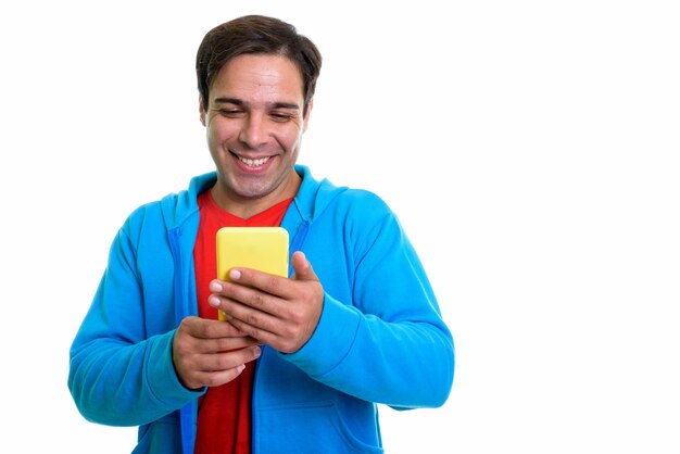 young happy Persian man smiling while using mobile phone