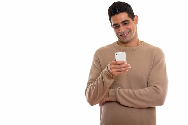 молодой счастливый персидский человек улыбается при использовании мобильного телефона