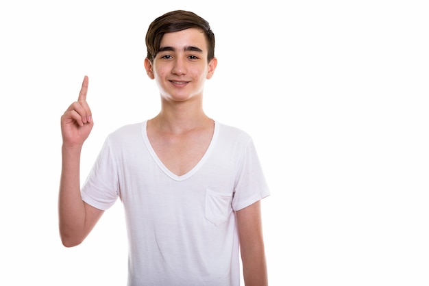 young happy Persian teenage boy smiling while pointing up