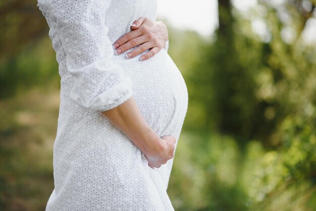 リラックスして自然の中での生活を楽しんでいる若い幸せな妊娠中の女性屋外ショットコピースペース