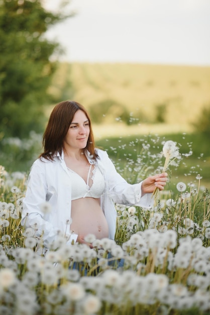 Young happy pregnant woman relaxing and enjoying life in nature Outdoor shot Copyspace