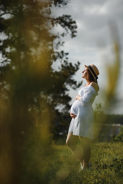 Young happy pregnant woman relaxing and enjoying life in nature Outdoor shot Copyspace