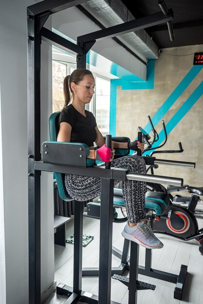 Foto giovane felice forte magra atleta sportiva donna in abbigliamento sportivo adattato allenamento di riscaldamento allenamento indoor