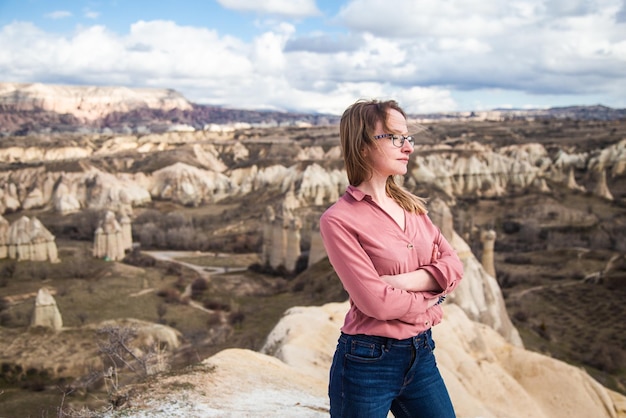 Young happy tourist woman traveler enjoying active vacation in valleys of Cappadocia Turkey