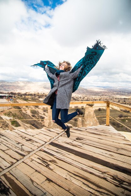 Young happy tourist woman traveler jumping enjoying a vacation in valleys Cappadocia Turkey