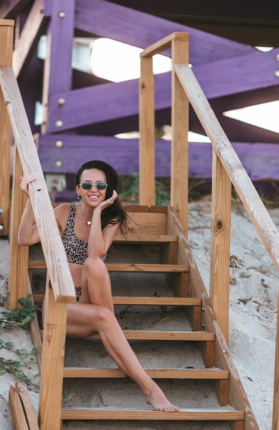 Foto giovane donna felice sulla spiaggia a godersi le sue vacanze estive