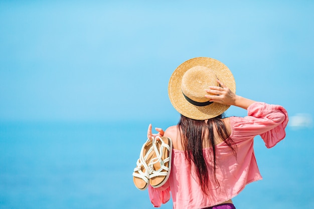 Young happy woman on the beach with mountain view