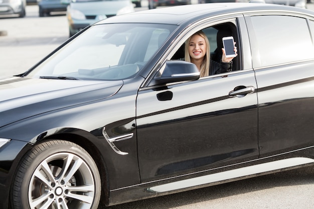 Young happy woman bought new modern car