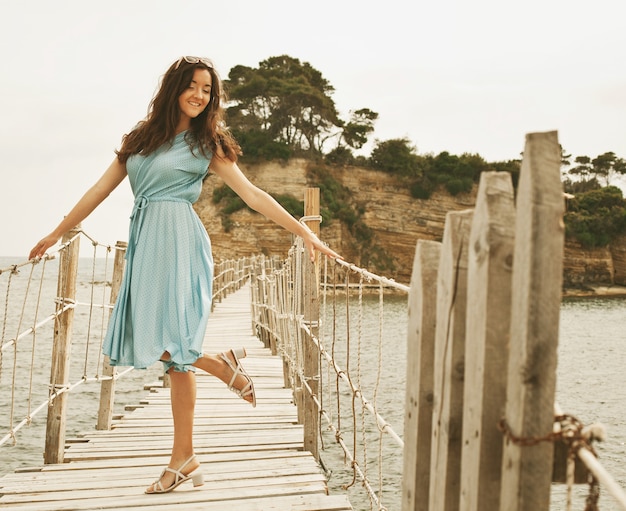 Giovane donna felice sul ponte vicino al mare, ora legale Foto Premium