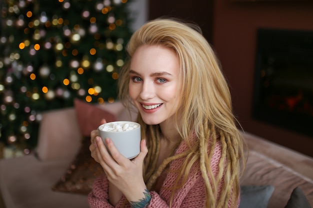 Giovane donna felice che celebra il natale a casa