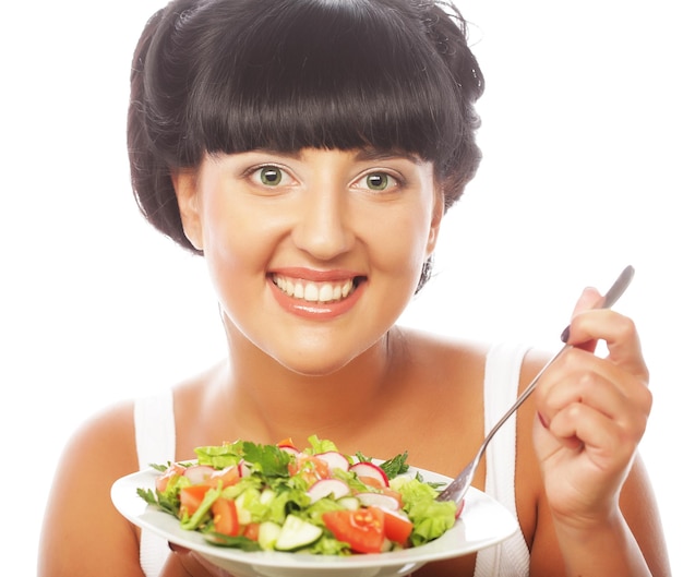 Photo young happy woman eating salad