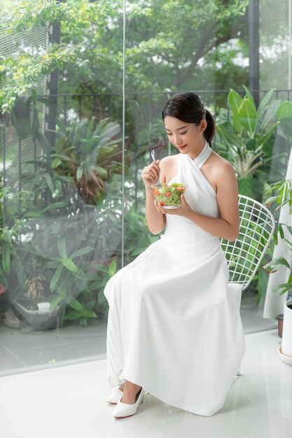 Young happy woman eating salad