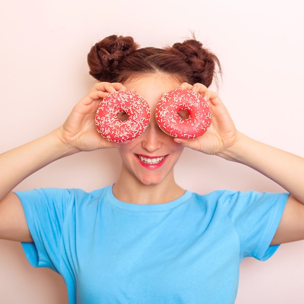 Young happy woman holding donuts