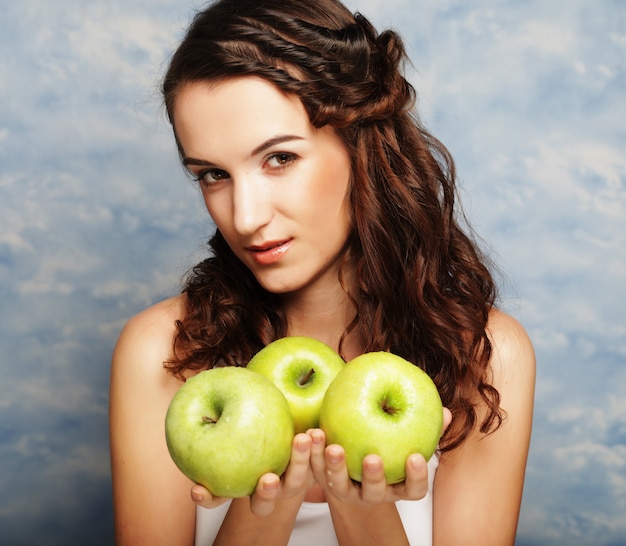 Young happy woman holding green apples. 