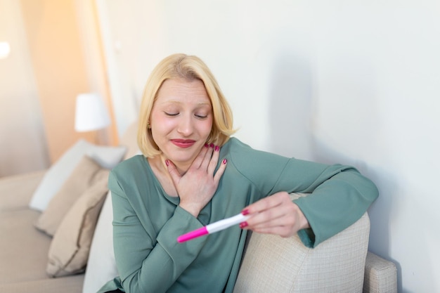 Young happy woman holding positive pregnancy test shallow depth of field Happy that she is going to have baby Finally pregnant