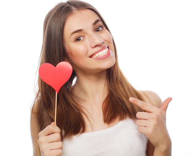 Young happy woman holding red paper heart and ready for party