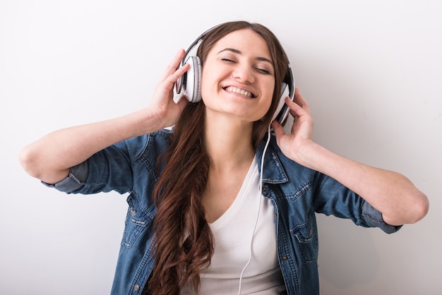 Young happy woman is listening to music with headphone.