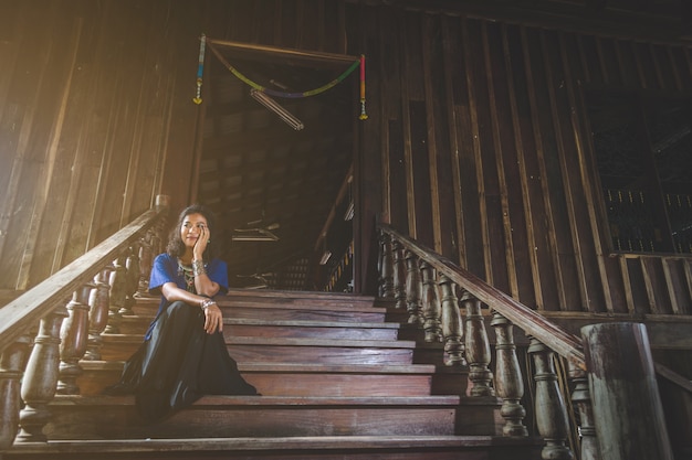 young happy woman on ladder in Temple, smiling happily with peace in mind