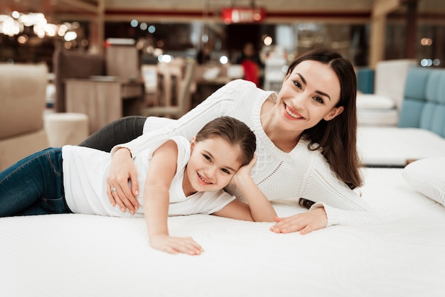 Young Happy Woman and Little Girl on Mattress