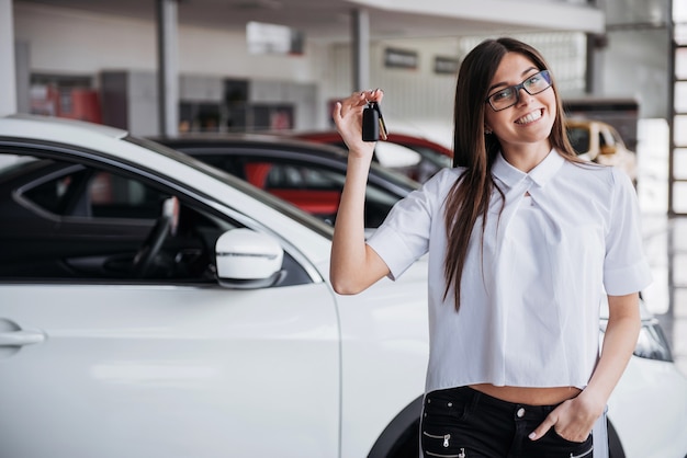 写真 手にキーが付いている車の近くの若い幸せな女