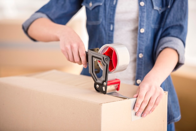 The young happy woman packing boxes.