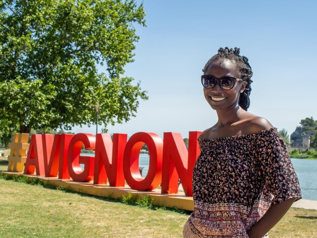 young happy woman portrait next to Avignon sign