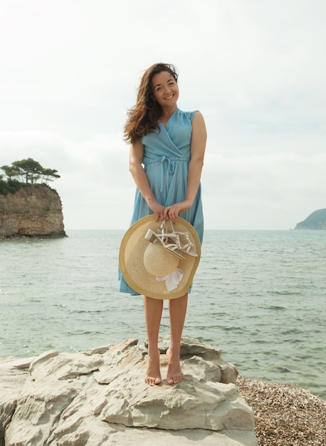 Young happy woman posing near sea